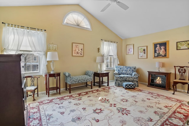 living area with ceiling fan, high vaulted ceiling, plenty of natural light, and carpet flooring