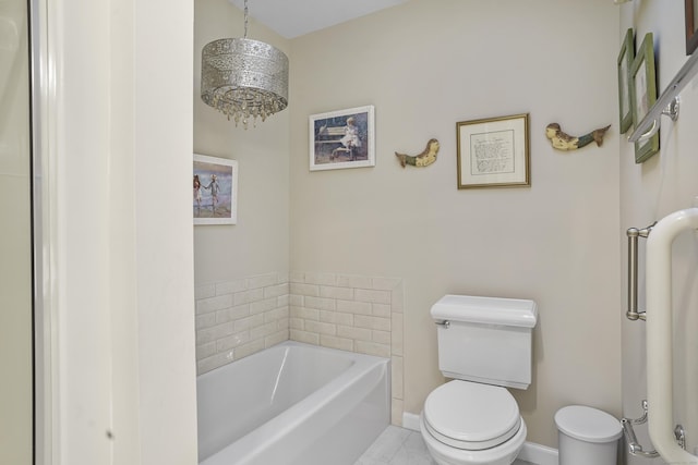 bathroom with a garden tub, toilet, and baseboards