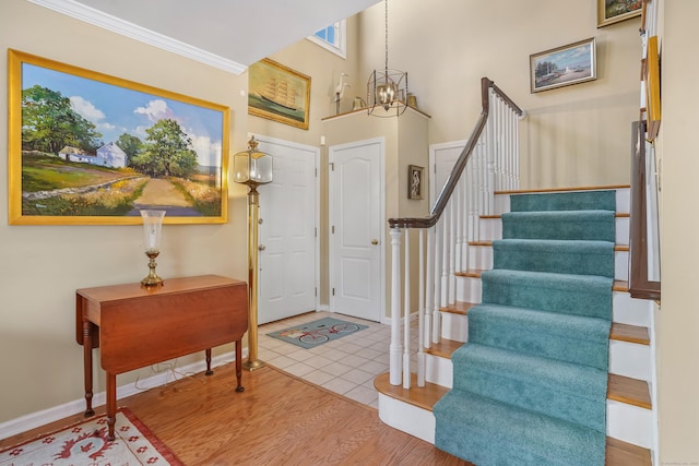 entrance foyer featuring baseboards, stairway, wood finished floors, and a notable chandelier