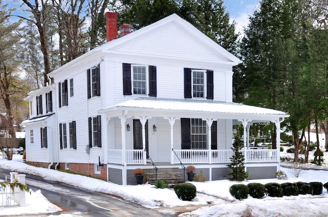 view of front of house with covered porch and a chimney