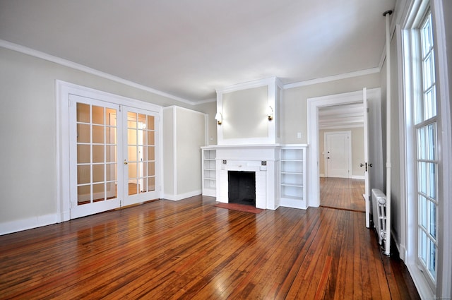 unfurnished living room with a fireplace, ornamental molding, dark wood-type flooring, and french doors