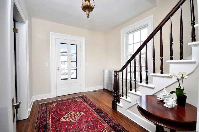 entrance foyer with a wealth of natural light, radiator, baseboards, and hardwood / wood-style floors