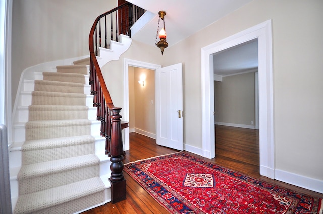 foyer with stairway, wood finished floors, and baseboards