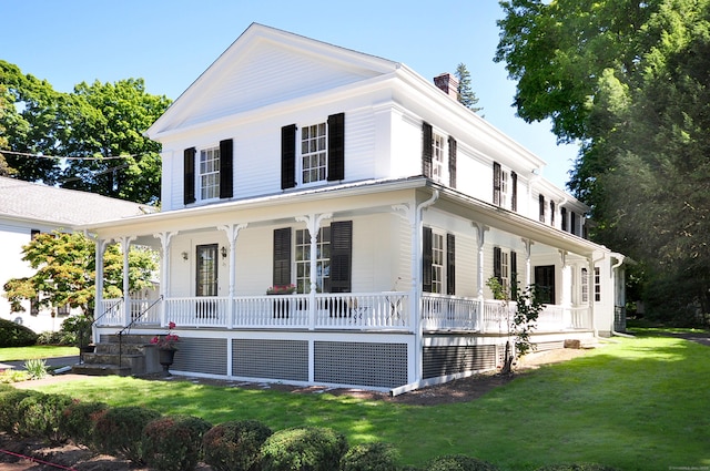 view of front facade featuring covered porch, a front lawn, and a chimney