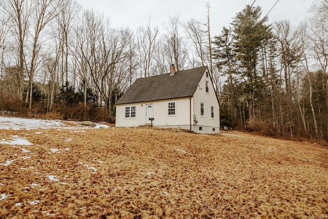 view of front of property featuring roof with shingles and a chimney