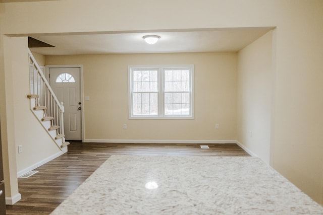 foyer featuring stairway, baseboards, visible vents, and dark wood-type flooring