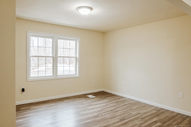 unfurnished room with baseboards and wood finished floors