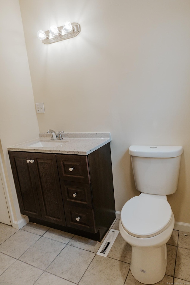 half bathroom featuring baseboards, visible vents, toilet, tile patterned floors, and vanity