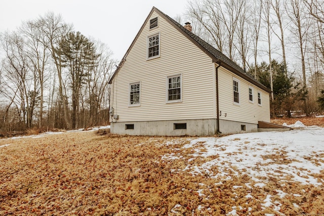 snow covered property featuring a chimney