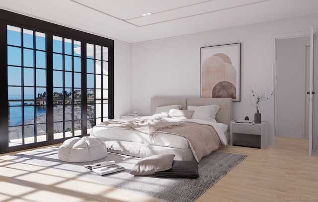 bedroom featuring multiple windows, wood finished floors, and a water view