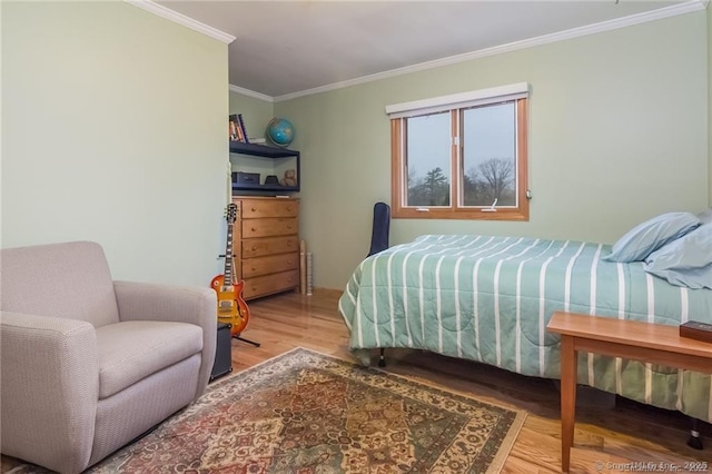 bedroom with wood finished floors and crown molding