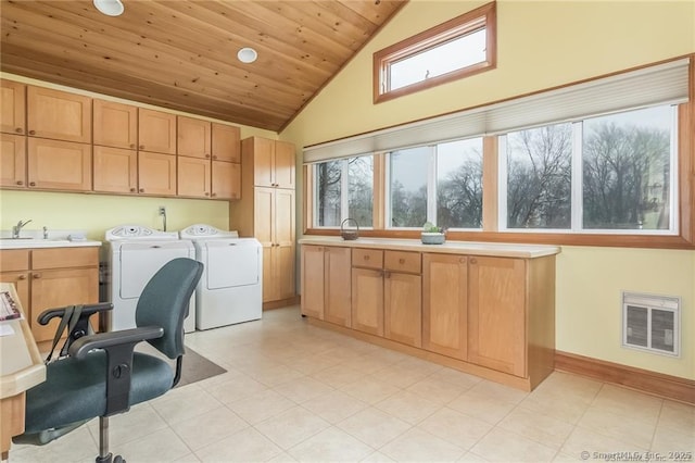 clothes washing area with washing machine and dryer, wood ceiling, cabinet space, and plenty of natural light