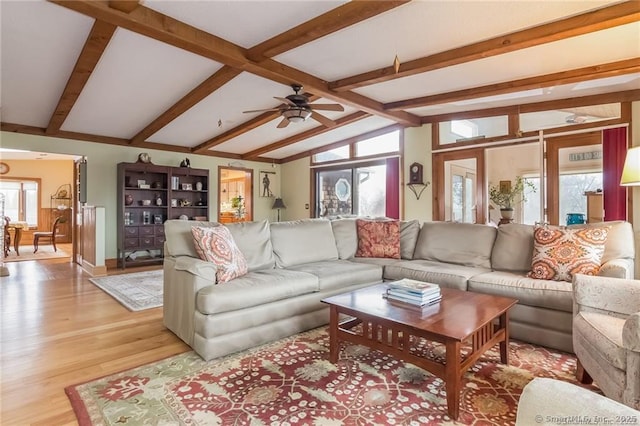 living room with lofted ceiling with beams, light wood-style floors, and a ceiling fan