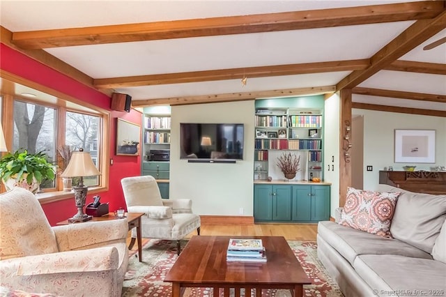 living room with vaulted ceiling with beams and light wood finished floors