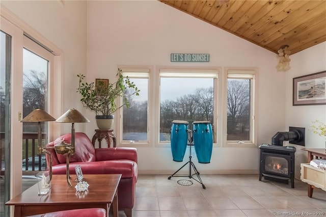 sitting room featuring high vaulted ceiling, wooden ceiling, a wood stove, and a healthy amount of sunlight