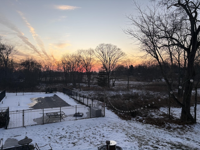 snowy yard featuring a patio and fence