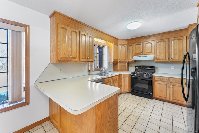 kitchen featuring a peninsula, range hood, light countertops, black appliances, and light tile patterned flooring