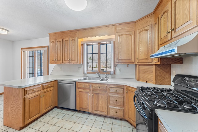 kitchen featuring a peninsula, black range with gas stovetop, stainless steel dishwasher, under cabinet range hood, and a sink