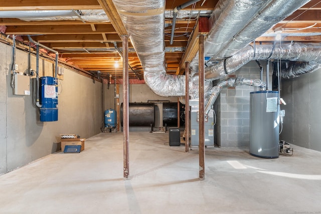 unfinished basement featuring water heater, heating unit, and heating fuel