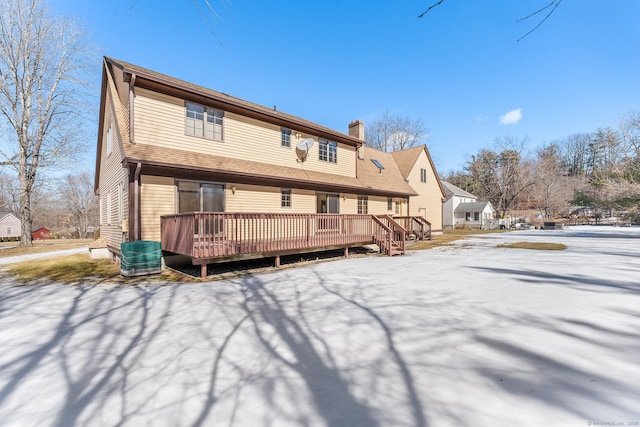 back of property with a chimney and a wooden deck