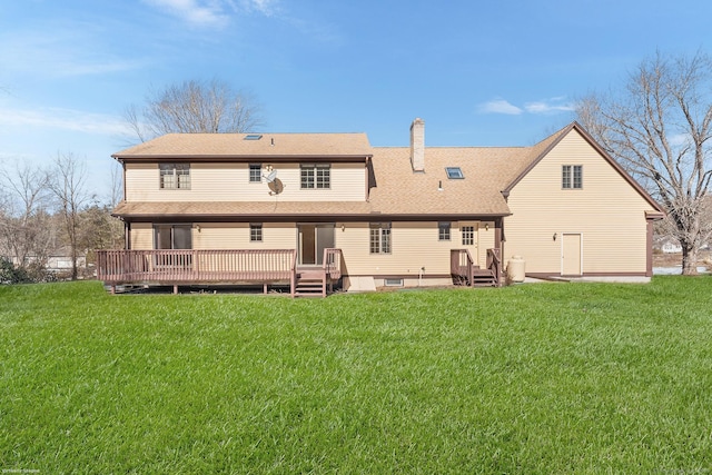 back of house featuring a yard, a chimney, a wooden deck, and roof with shingles