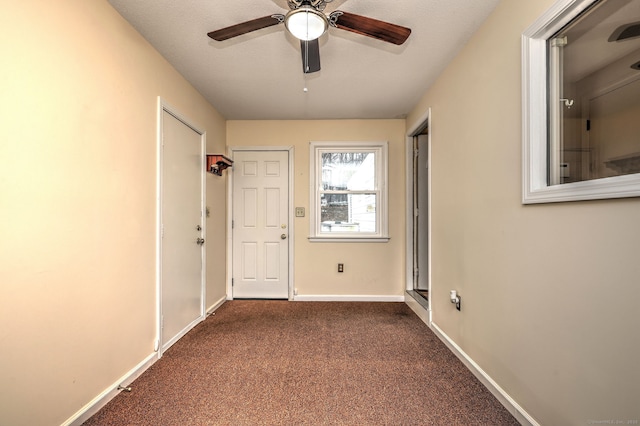 hallway featuring dark colored carpet and baseboards