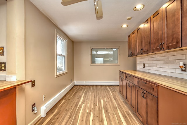 kitchen featuring a baseboard heating unit, wood counters, baseboards, and tasteful backsplash