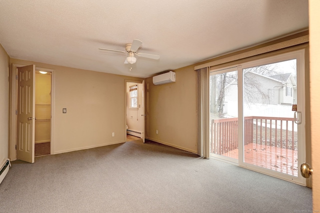 spare room with baseboards, a wall unit AC, a baseboard radiator, carpet, and a textured ceiling