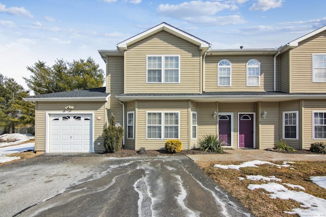 multi unit property featuring an attached garage and aphalt driveway