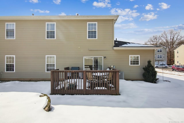 snow covered property with a wooden deck