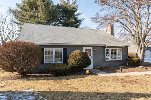 view of front of property with a chimney and a front lawn