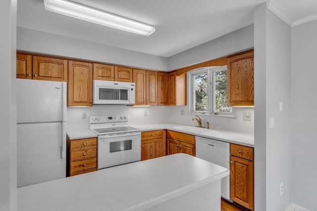 kitchen featuring light countertops, white appliances, a sink, and brown cabinets