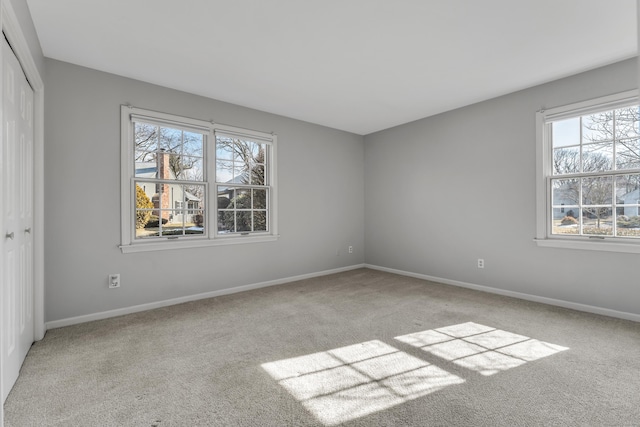 unfurnished bedroom with baseboards, a closet, and light colored carpet