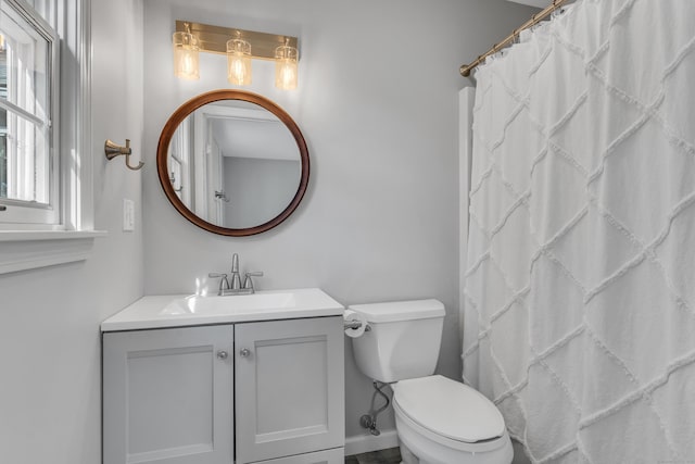 bathroom featuring baseboards, a shower with shower curtain, vanity, and toilet