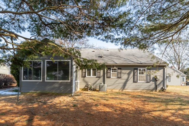 back of property featuring cooling unit and a yard