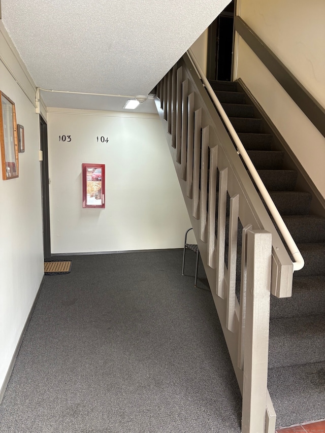 interior space featuring a textured ceiling, stairs, and carpet floors