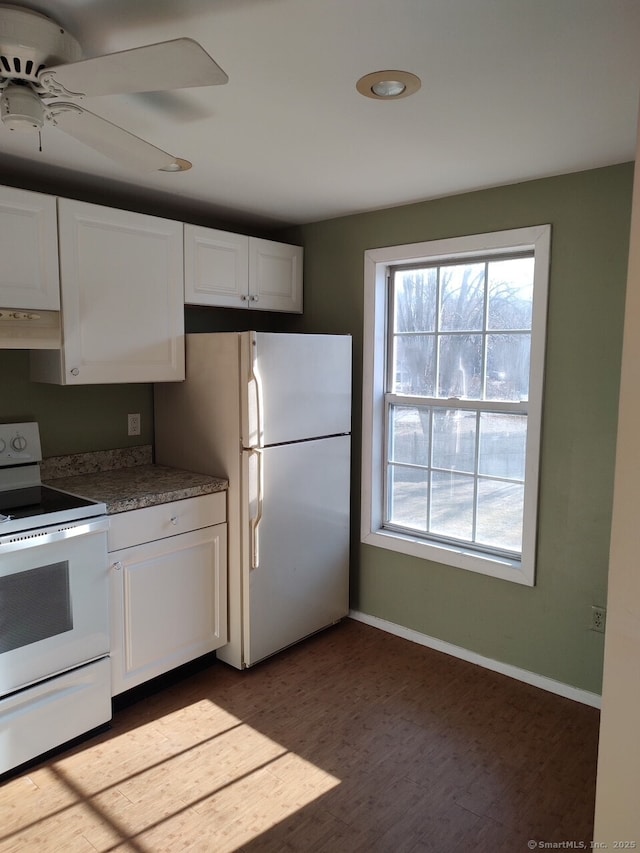 kitchen featuring white appliances, white cabinetry, and exhaust hood