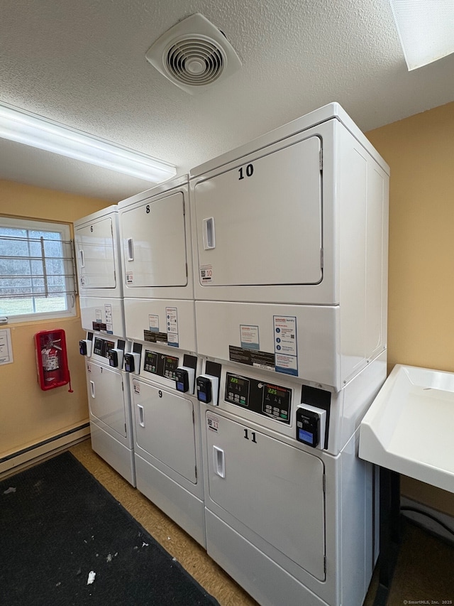 common laundry area with stacked washer / drying machine, independent washer and dryer, a textured ceiling, and visible vents