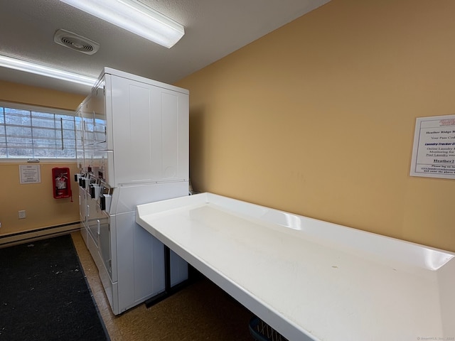 common laundry area with visible vents, baseboard heating, and stacked washing maching and dryer