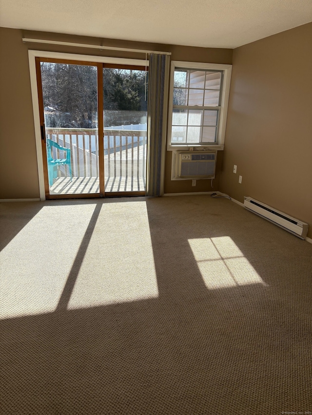 carpeted spare room with a baseboard heating unit, baseboards, and a wall unit AC