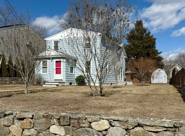 view of front of house with a storage shed and an outbuilding