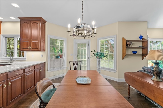 dining room with plenty of natural light, baseboards, dark wood finished floors, and a chandelier