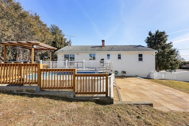 rear view of house with a patio area, fence, and a wooden deck