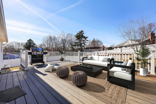 wooden terrace with area for grilling, fence, and an outdoor living space