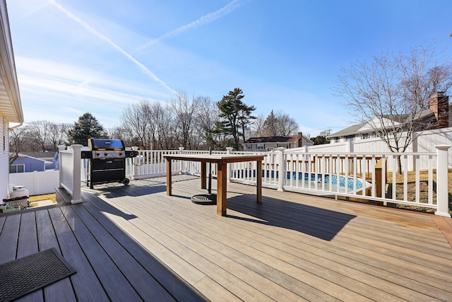 wooden terrace featuring a fenced backyard and area for grilling