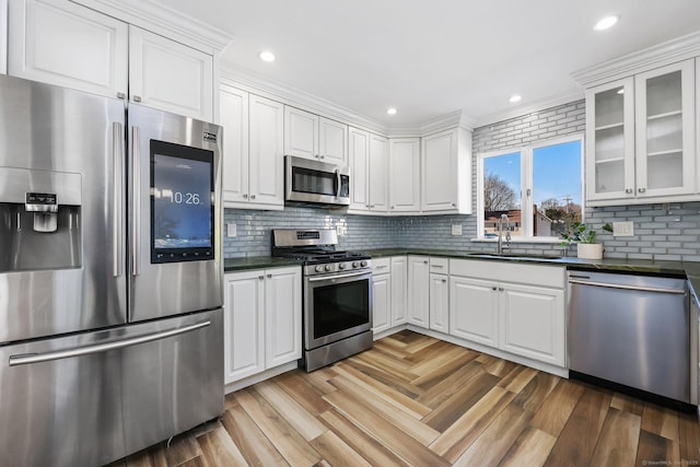 107 Emerson Dr, Stratford, CT 06614 - kitchen featuring stainless steel appliances, a sink, dark countertops, glass insert cabinets, and white cabinets