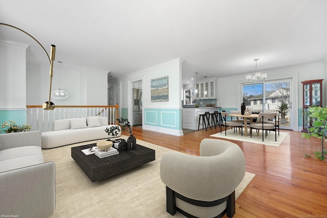 107 Emerson Dr, Stratford, CT 06614 - living area featuring a chandelier, crown molding, light wood finished floors, a decorative wall, and a wainscoted wall