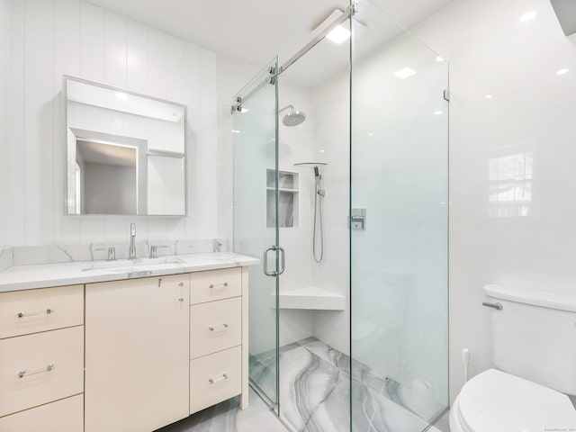 full bathroom featuring vanity, a shower stall, and toilet