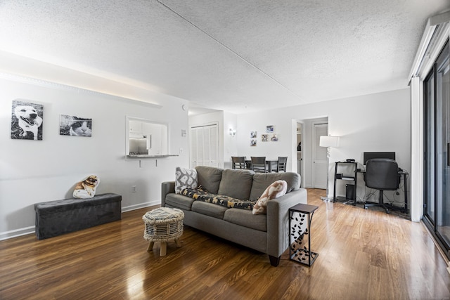 living room featuring a textured ceiling, wood finished floors, and baseboards