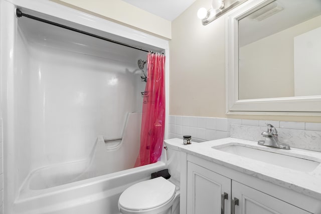 bathroom with toilet, vanity, tile walls, wainscoting, and shower / bath combination with curtain